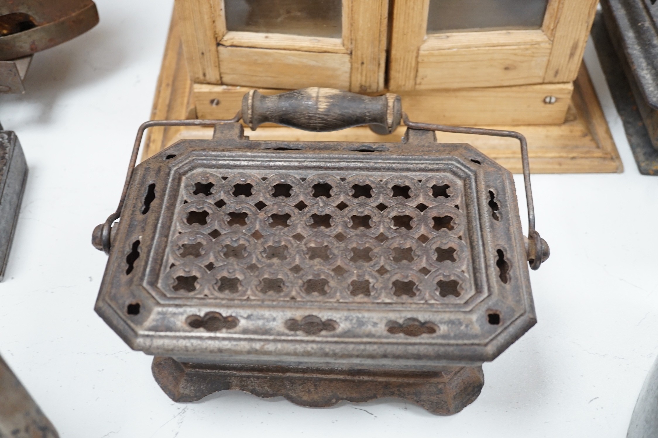 Four French coal/slug irons, three trivets and a stripped pine glazed cabinet, 37cm high